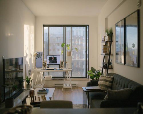 Home office desk setup placed perpendicular to a large window filtering soft day light